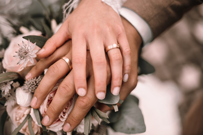 Hand in Hand mit Ringe und Blumen